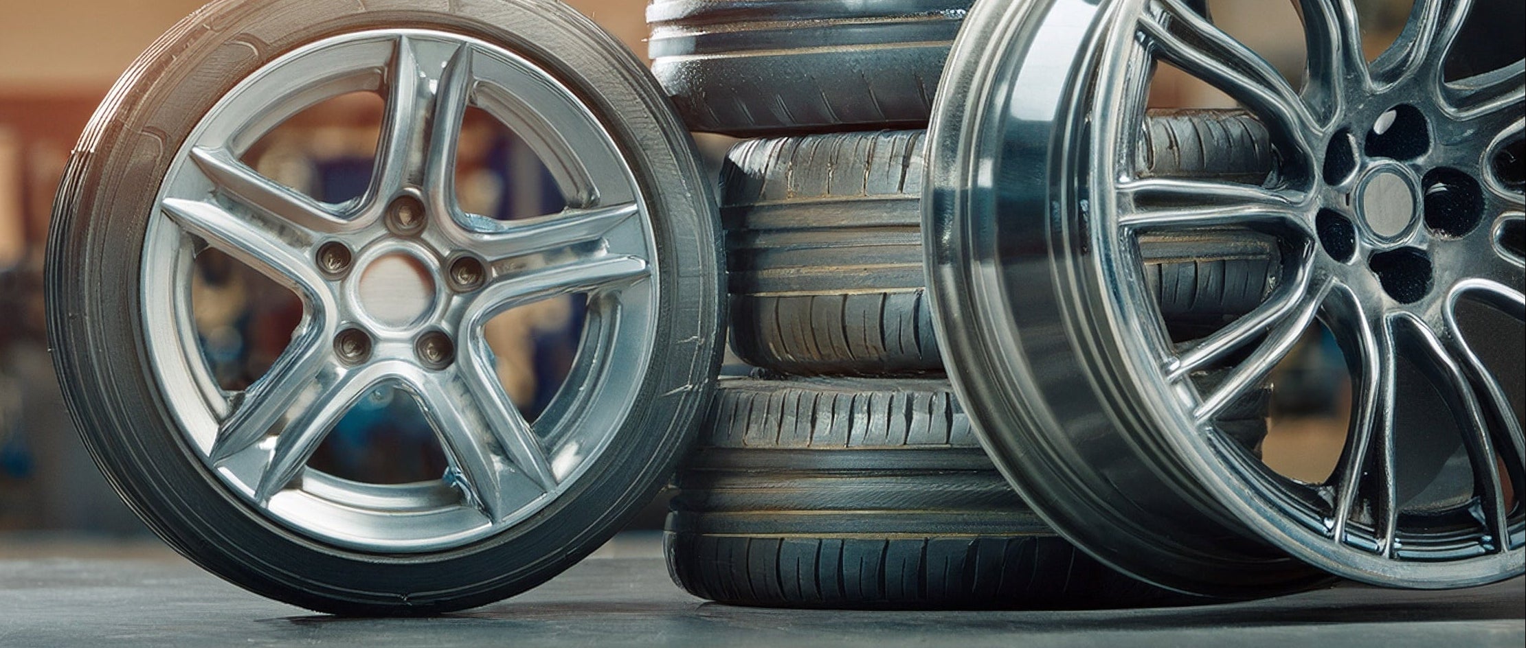 Stack of tires and car wheels in a garage setting